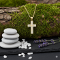 Złocony krzyżyk z białymi cyrkoniami – biżuteria religijna w naturalnej aranżacji