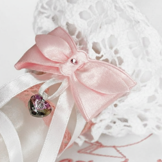 zbliżenie na zdobienie kryształkiem - Świeca i Szatka do Chrztu „Glamour Lace – Blask Wiary” – różowy zestaw z koronką i kryształkiem Preciosa®