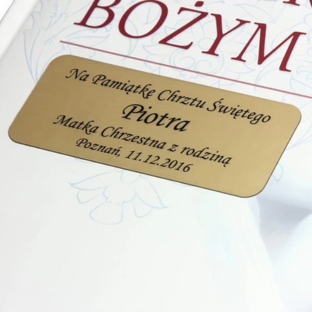 Album Jestem dzieckiem Bożym – makro złotej tabliczki z grawerem